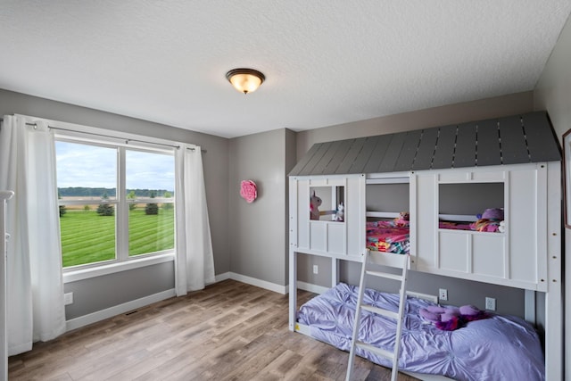 6339 140th Ave SE, Clear Lake, MN 55319 - bedroom featuring wood finished floors and a textured ceiling