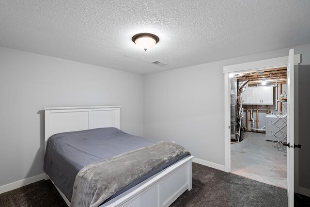 6339 140th Ave SE, Clear Lake, MN 55319 - bedroom with washer / dryer, dark colored carpet, and a textured ceiling