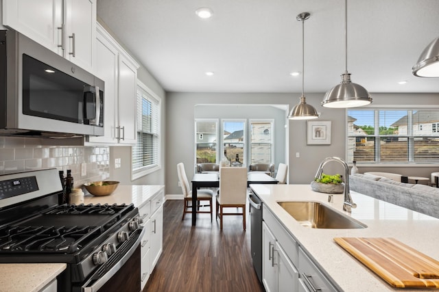7665 Swan St, Lino Lakes, MN 55038 - kitchen with stainless steel appliances, dark wood-style flooring, light stone countertops, recessed lighting, and tasteful backsplash
