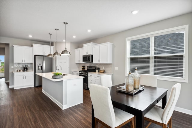 7665 Swan St, Lino Lakes, MN 55038 - kitchen with stainless steel appliances, an island with sink, dark wood-style flooring, decorative backsplash, and recessed lighting
