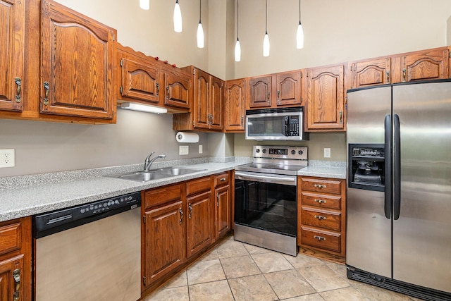 3514 Douglas Dr N, Crystal, MN 55422 - kitchen featuring stainless steel appliances, brown cabinetry, light countertops, light tile patterned flooring, and pendant lighting
