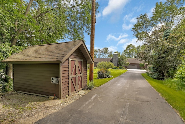 72959 235th St, Dassel, MN 55325 - view of front of property with a storage unit, a detached garage, and roof with shingles