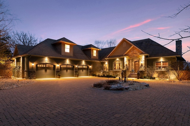 12159 Quail Avenue Ln N, Stillwater, MN 55082 - craftsman-style home featuring stone siding, an attached garage, a chimney, and curved driveway