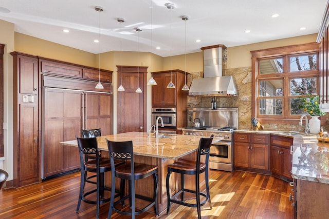 12159 Quail Avenue Ln N, Stillwater, MN 55082 - kitchen featuring premium appliances, a sink, wall chimney exhaust hood, dark wood-style floors, and light stone countertops