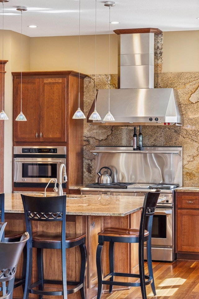 12159 Quail Avenue Ln N, Stillwater, MN 55082 - kitchen featuring appliances with stainless steel finishes, wall chimney range hood, wood finished floors, tasteful backsplash, and a sink