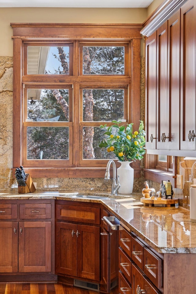 12159 Quail Avenue Ln N, Stillwater, MN 55082 - kitchen featuring a sink, light stone countertops, and brown cabinetry