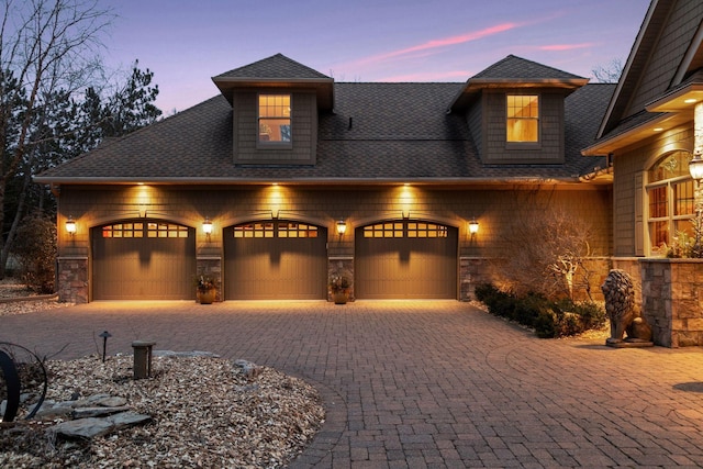 12159 Quail Avenue Ln N, Stillwater, MN 55082 - craftsman-style house featuring stone siding, an attached garage, roof with shingles, and decorative driveway