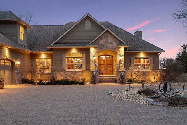 12159 Quail Avenue Ln N, Stillwater, MN 55082 - craftsman-style home with stone siding, a chimney, decorative driveway, and an attached garage