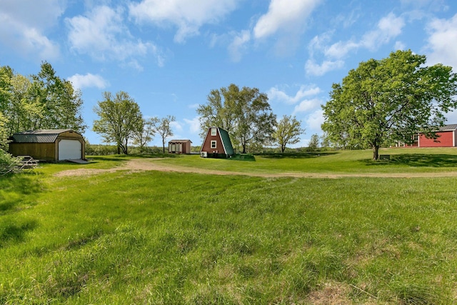 19663 County Road 9 NE, New London Twp, MN 56273 - view of grassy yard featuring an outdoor structure, driveway, a garage, and a barn