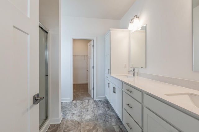 11452 Queens Ct N, Lake Elmo, MN 55042 - bathroom featuring a shower stall, double vanity, a spacious closet, and baseboards