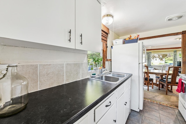 926 Bellows St, West Saint Paul, MN 55118 - kitchen with freestanding refrigerator, healthy amount of natural light, decorative backsplash, and white cabinets