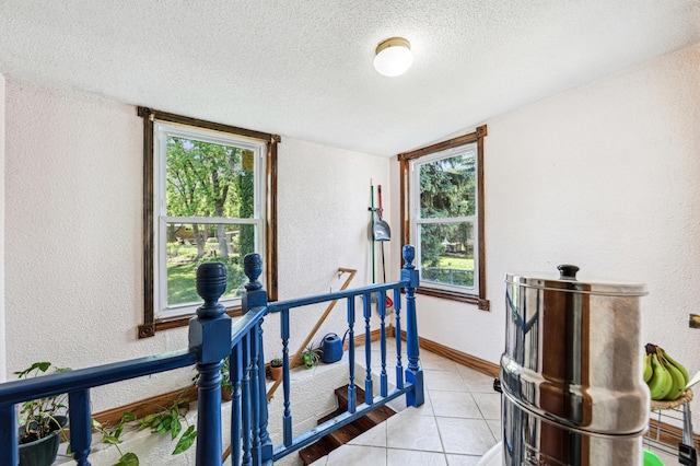 926 Bellows St, West Saint Paul, MN 55118 - corridor with a textured wall, a textured ceiling, light tile patterned floors, and an upstairs landing