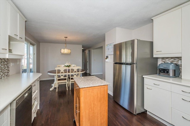 3003 Hammond Ave, Superior, WI 54880 - kitchen featuring appliances with stainless steel finishes, decorative backsplash, a center island, light countertops, and a textured ceiling