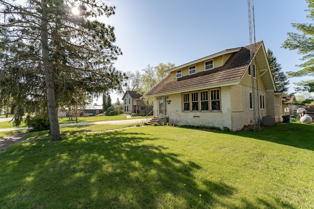 339 Cherry St E, Mazeppa, MN 55956 - back of property with central air condition unit, stucco siding, and a lawn