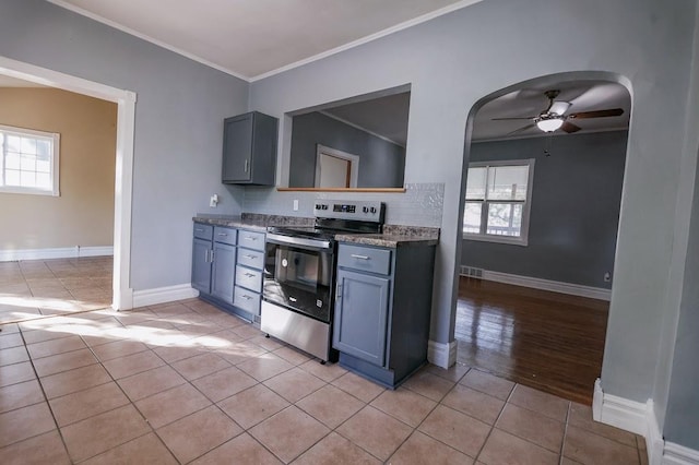 546 2nd St SE, Perham, MN 56573 - kitchen featuring stainless steel electric stove, light tile patterned floors, a ceiling fan, ornamental molding, and baseboards