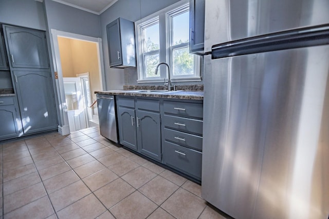 546 2nd St SE, Perham, MN 56573 - kitchen with freestanding refrigerator, stainless steel dishwasher, a sink, light tile patterned floors, and dark countertops