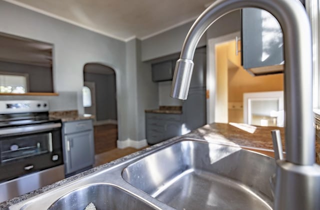 546 2nd St SE, Perham, MN 56573 - kitchen view of stainless steel electric range oven, arched walkways, and a sink
