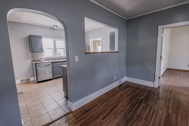 546 2nd St SE, Perham, MN 56573 - unfurnished room featuring ornamental molding, wood finished floors, baseboards, a sink, and arched walkways