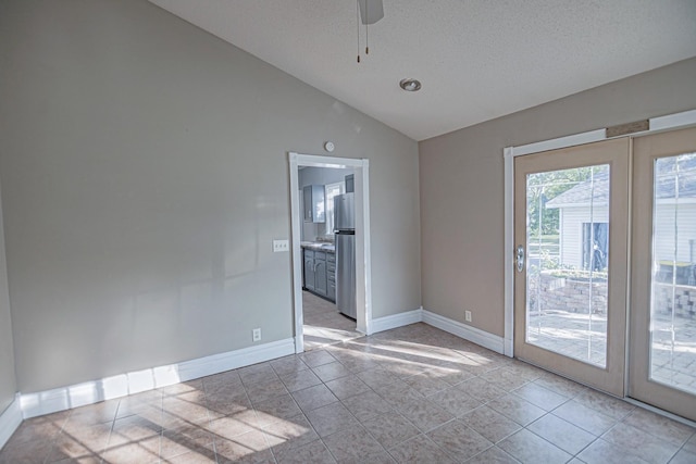 546 2nd St SE, Perham, MN 56573 - empty room featuring vaulted ceiling, ceiling fan, baseboards, light tile patterned flooring, and a textured ceiling