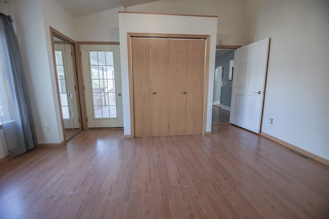 546 2nd St SE, Perham, MN 56573 - unfurnished bedroom with wood finished floors, arched walkways, and baseboards