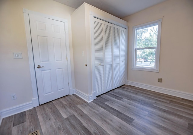 546 2nd St SE, Perham, MN 56573 - unfurnished bedroom with wood finished floors, a closet, and baseboards