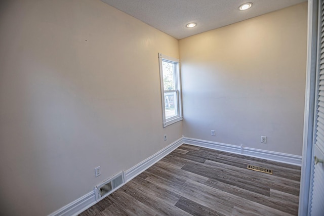 546 2nd St SE, Perham, MN 56573 - unfurnished room with baseboards, dark wood-style flooring, recessed lighting, and a textured ceiling