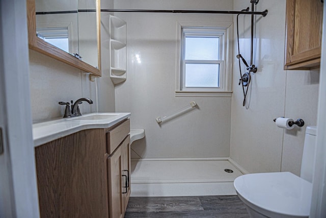 546 2nd St SE, Perham, MN 56573 - bathroom with toilet, a shower, vanity, and wood finished floors