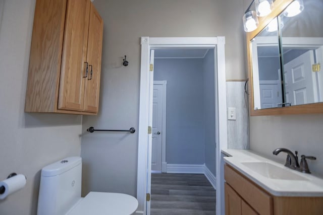 546 2nd St SE, Perham, MN 56573 - bathroom featuring toilet, wood finished floors, vanity, and baseboards
