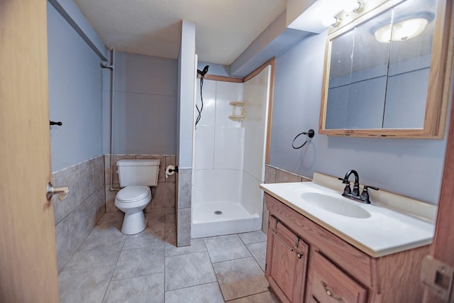 546 2nd St SE, Perham, MN 56573 - bathroom featuring a shower, toilet, vanity, tile walls, and tile patterned floors
