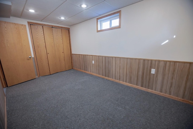 546 2nd St SE, Perham, MN 56573 - unfurnished bedroom featuring wainscoting, carpet, a closet, and wood walls