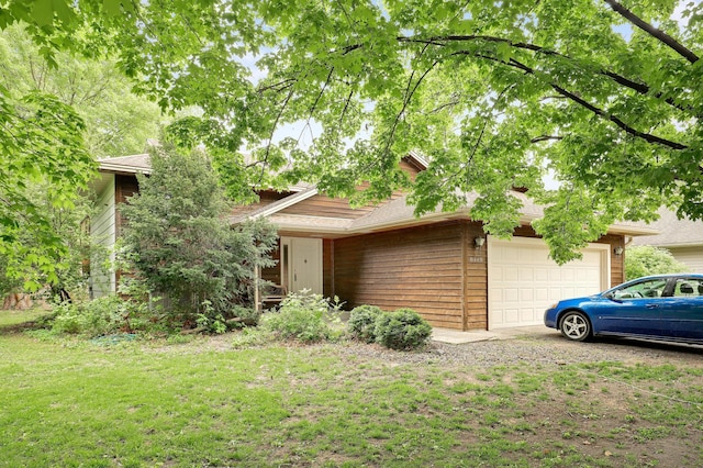 obstructed view of property featuring an attached garage and a front yard