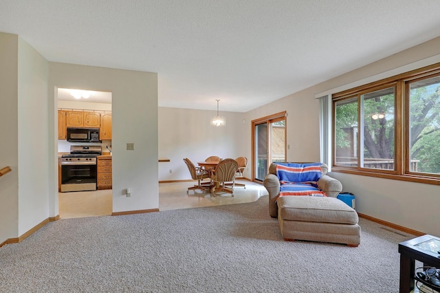 sitting room with light colored carpet, baseboards, and a chandelier