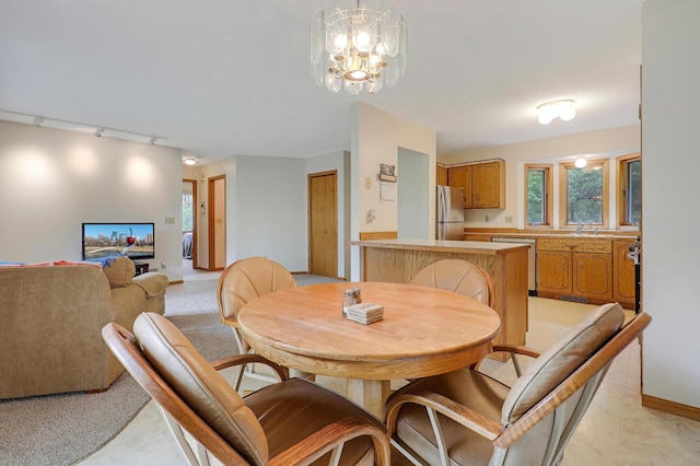 dining space with rail lighting, baseboards, and a chandelier