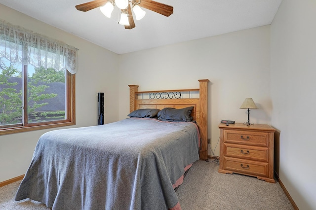 bedroom featuring light colored carpet, baseboards, and ceiling fan