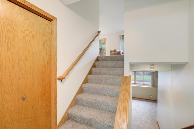 stairs with carpet, plenty of natural light, and baseboards