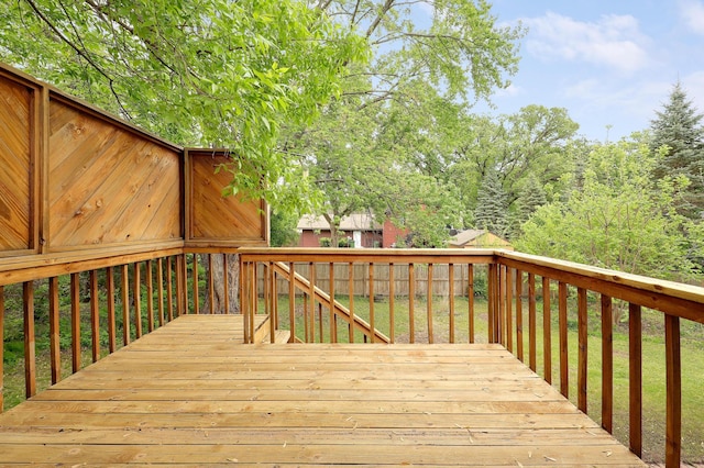 wooden deck featuring a lawn