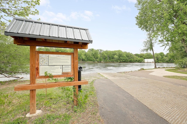 view of property's community with mail area and a water view