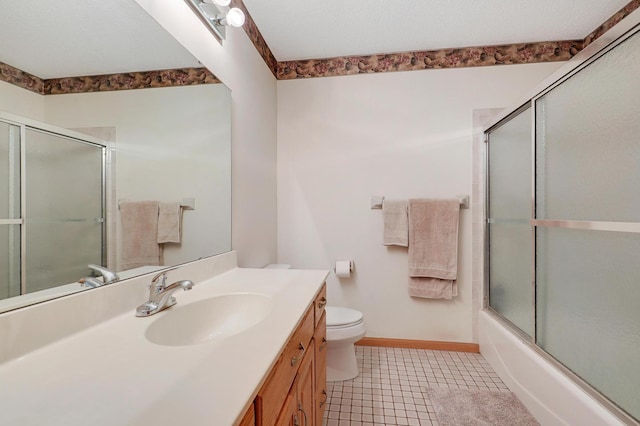 bathroom with vanity, baseboards, toilet, tile patterned floors, and combined bath / shower with glass door