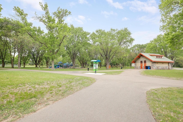 surrounding community featuring curved driveway and a yard