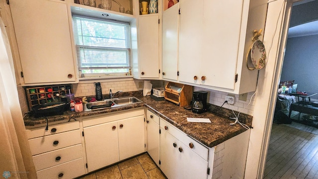 728 8th St N, Fargo, ND 58102 - kitchen with a sink, tasteful backsplash, dark countertops, and white cabinetry