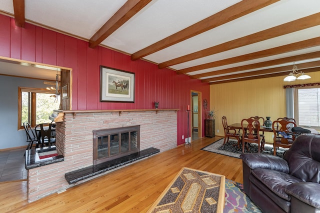 42340 County 50th Blvd, Minneola Twp, MN 55983 - living room featuring a chandelier, beam ceiling, a fireplace, and wood finished floors