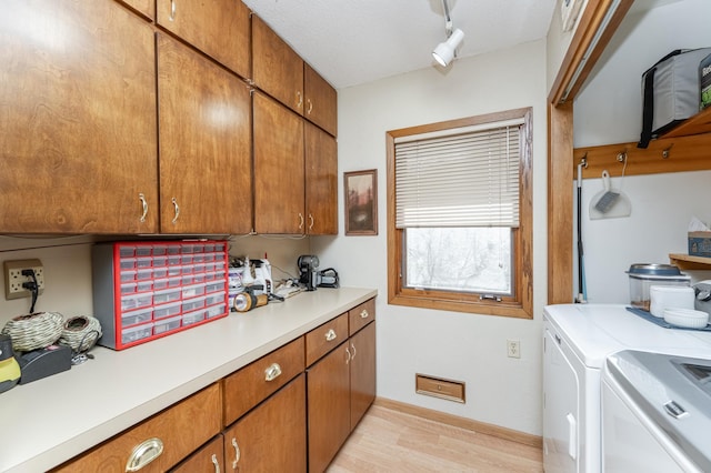 42340 County 50th Blvd, Minneola Twp, MN 55983 - laundry room featuring cabinet space, light wood-style floors, washing machine and clothes dryer, track lighting, and baseboards