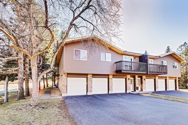 2245 Pinehurst St, Stillwater, MN 55082 - view of front of home with asphalt driveway, a garage, a balcony, and brick siding