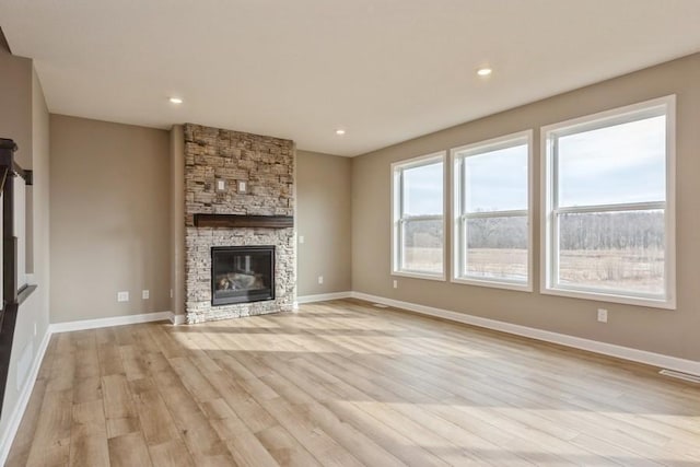 14965 105th Pl N, Maple Grove, MN 55369 - unfurnished living room featuring light wood-type flooring, baseboards, a stone fireplace, and recessed lighting