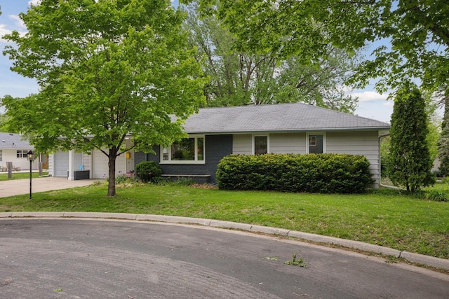 5 Hillside Ct, Northfield, MN 55057 - ranch-style home with concrete driveway, a front lawn, an attached garage, and roof with shingles