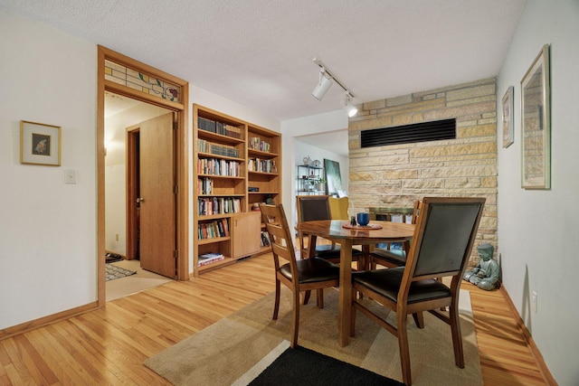 5 Hillside Ct, Northfield, MN 55057 - dining room with light wood-type flooring, rail lighting, baseboards, and a textured ceiling