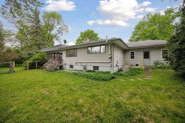 5 Hillside Ct, Northfield, MN 55057 - rear view of property featuring a sunroom, a lawn, a chimney, and central air condition unit