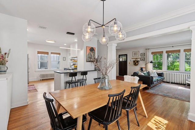1310 Fairmount Ave, Saint Paul, MN 55105 - dining area with decorative columns, radiator heating unit, light wood finished floors, baseboards, and recessed lighting