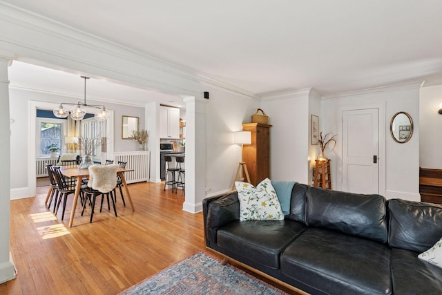 1310 Fairmount Ave, Saint Paul, MN 55105 - living area with a chandelier, radiator heating unit, light wood-type flooring, crown molding, and baseboards