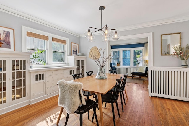 1310 Fairmount Ave, Saint Paul, MN 55105 - dining space featuring radiator heating unit, a chandelier, ornamental molding, and light wood-style flooring